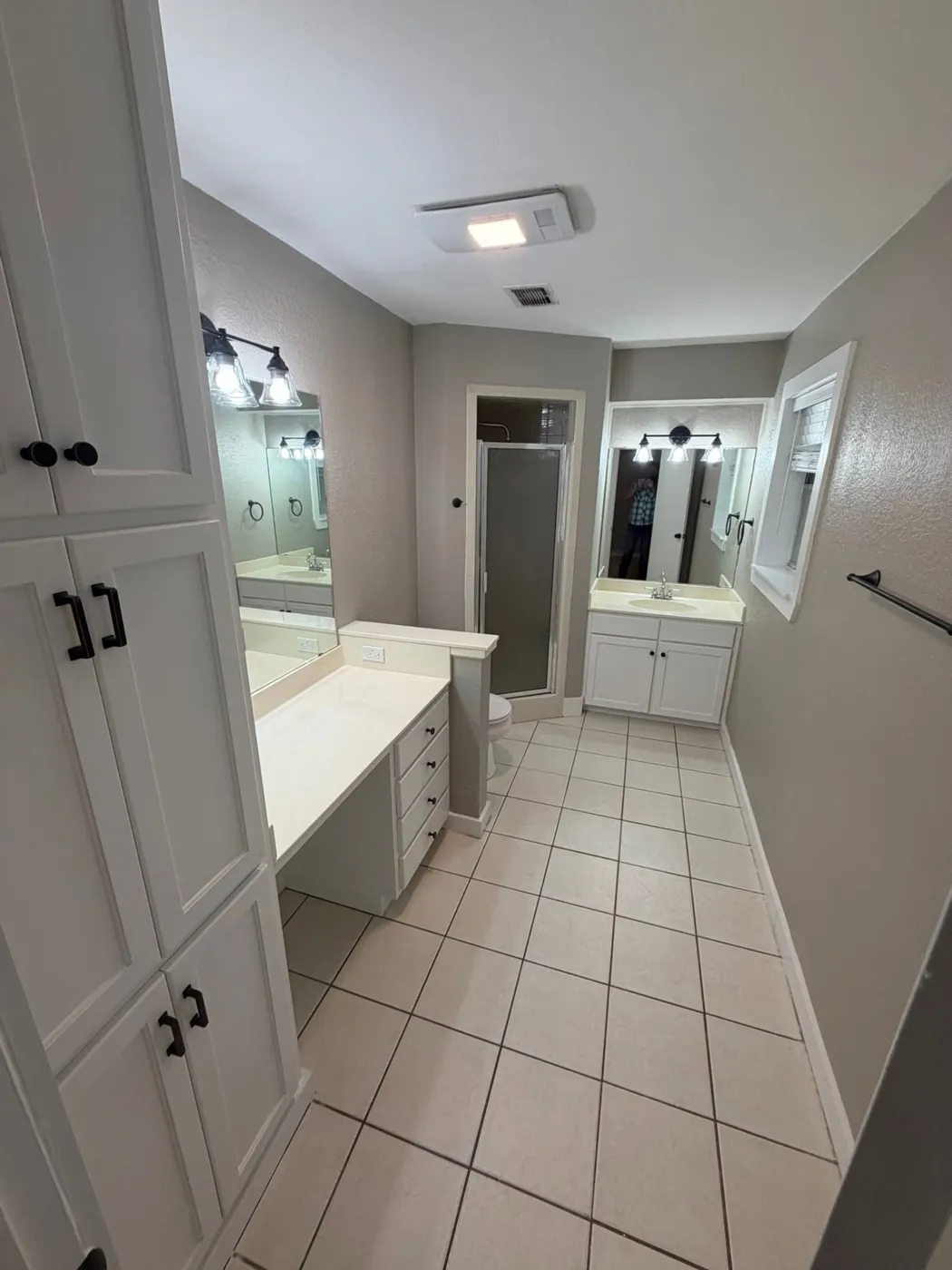 Primary bathroom with painted cabinets and new bronze fixtures