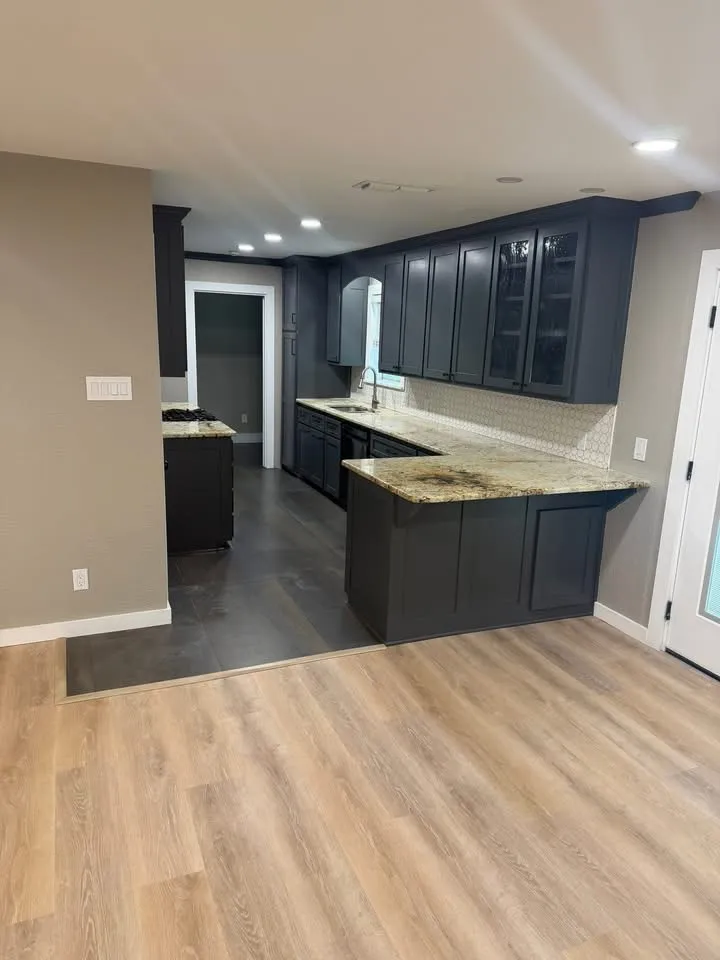 Remodeled kitchen with charcoal shaker cabinets and granite counters