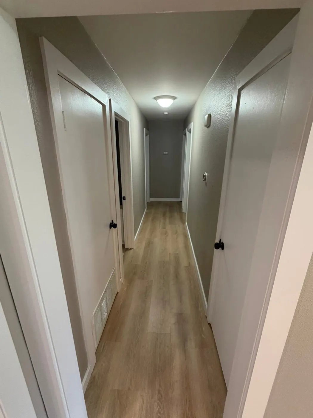 Bedroom hallway with new flooring and freshly painted doors