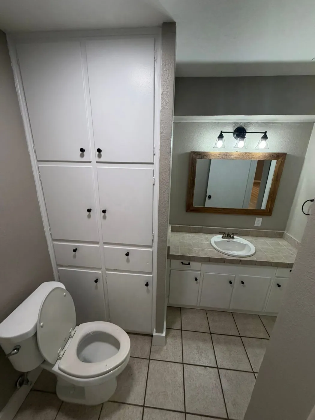 Bathroom with painted built-in linen cabinets and updated hardware